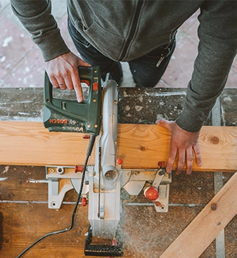 Handwerker schneidet Holzbrett mit Handkreissäge